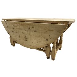 Traditional stripped pine dining table, circular drop-leaf top over double gate-leg action base with turned supports united by turned stretchers