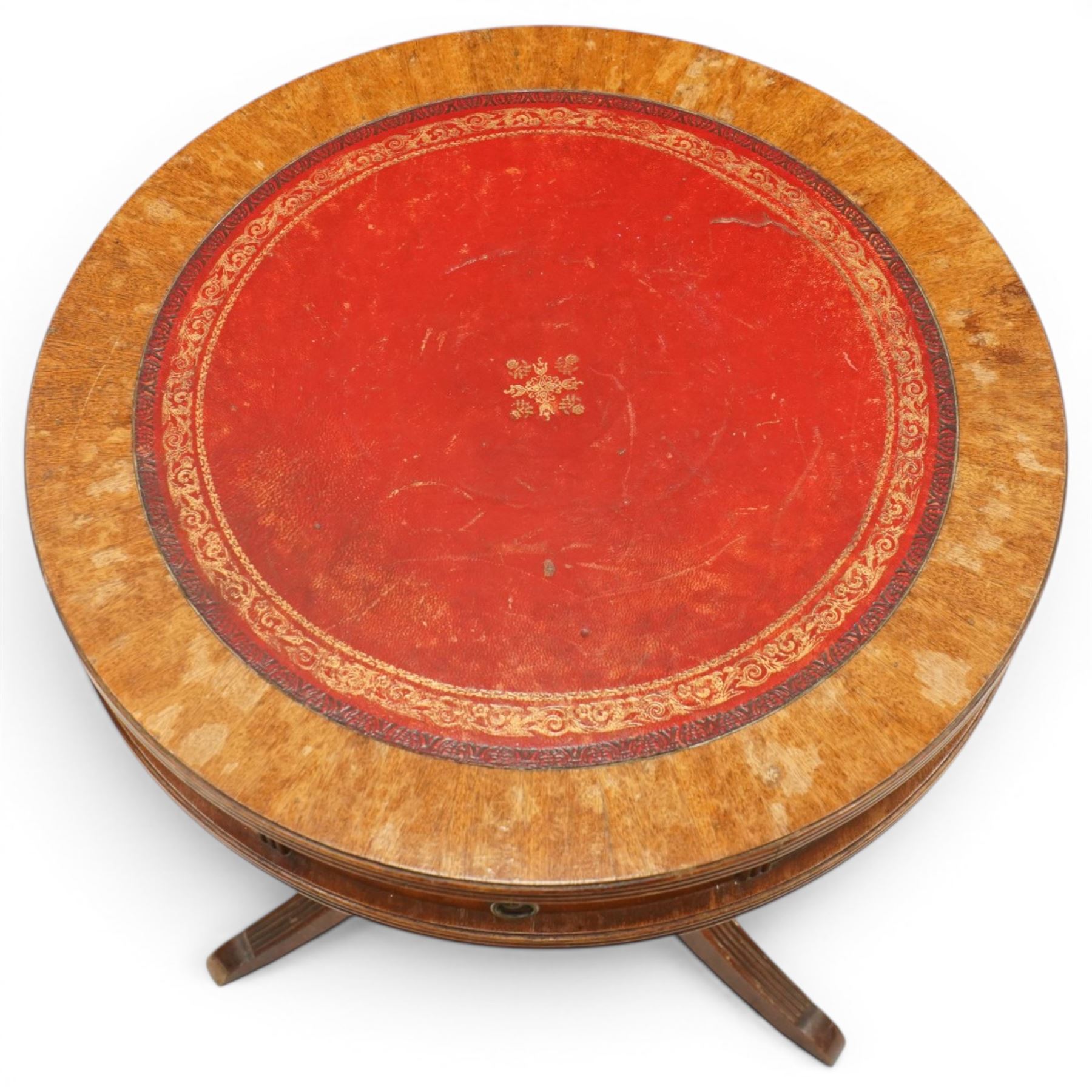 Regency style mahogany drum table, circular red leather inset top with gilt and blind tooling, bird's-eye maple crossbanded border, fitted with two opposing pull-out slides, on turned pedestal and three outswept support