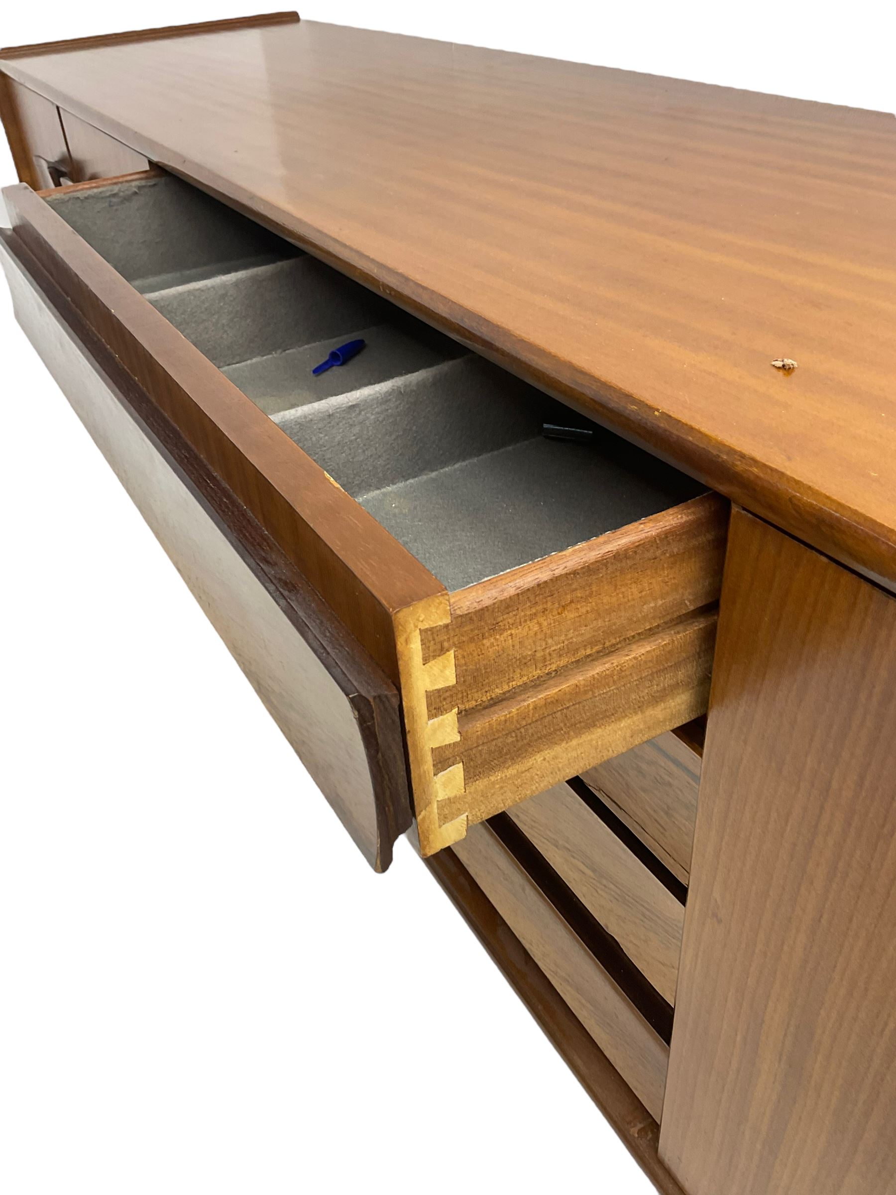 Elliots of Newbury (EoN) - mid-20th century teak sideboard, fitted with four central doors flanked by fall-front cupboard and a double cupboard, each with concave wooden handles