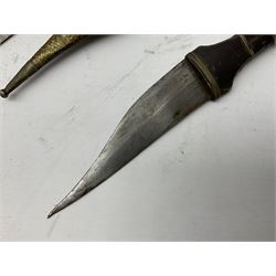 Near pair of African Moroccan Berber tribal Shula daggers each with engraved 39cm curving fullered steel blade, carved and inlaid horn grip and leather covered scabbard L57cm overall; kindjal style dagger with brass covered and jewelled grip and scabbard; another Eastern dagger with leather covered grip and scabbard; and a large Eastern knife with animal hide scabbard (5)
