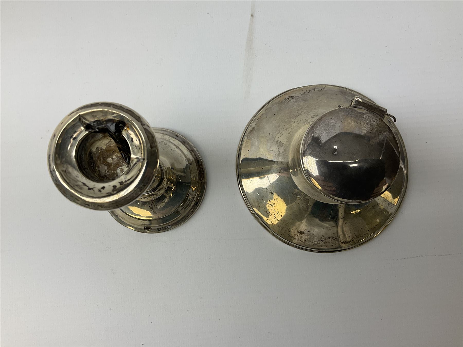 1920's silver mounted capstan inkwell, hallmarked Charles Boyton & Son Ltd, London 1929, together with an early 20th century silver mounted dwarf candlestick, hallmarked A J Pepper & Co, Birmingham 1918