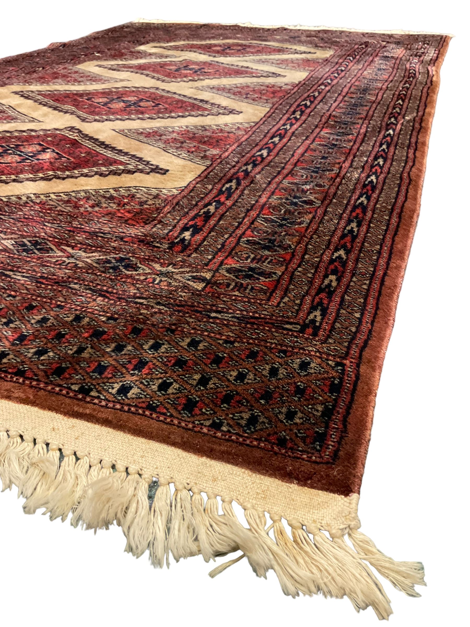 Persian rug, the interconnecting field decorated with four lozenge medallions, multiple band border with overall geometric design decorated with stylised flower head motifs