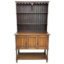 Early to mid-20th century oak dresser, raised two tier plate tack over two linenfold panelled doors, on spiral turned supports united by undertier 