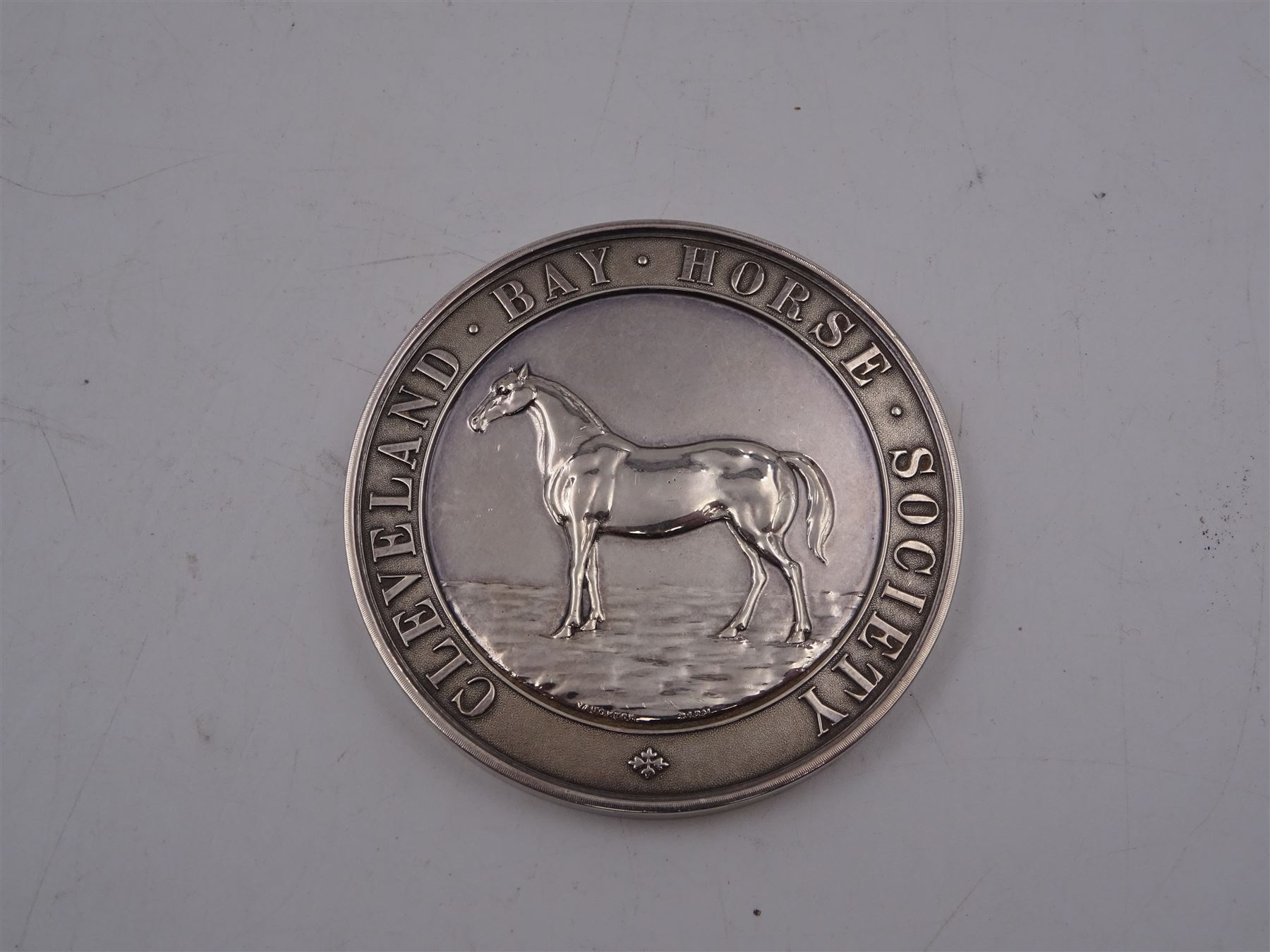 Edwardian silver medal, of circular form, embossed to front with a bay horse and inscribed Cleveland Bay Horse Society, engraved verso 1904 Egton Show won by Rock Dove No 1000 bred at Rock Head by W Duell, hallmarked Vaughton & Sons, Birmingham 1903, contained within fitted case, D6.3cm