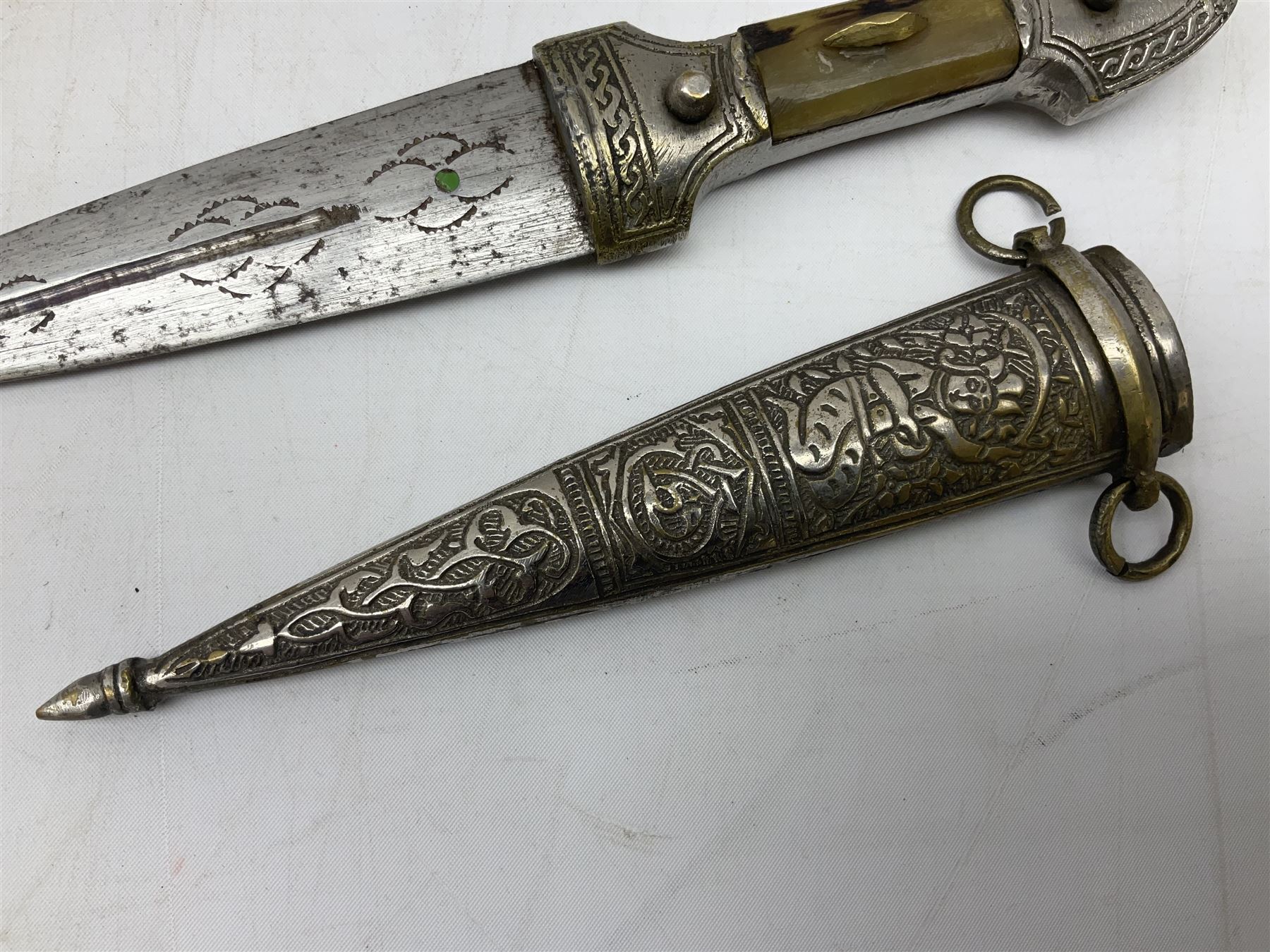 Caucasian qama or kindjal dagger, the 15cm pointed double edged blade with centre fuller and two-piece horn grip;  in nickel plated scabbard with panels of figures and script L28.5cm overall; and eastern knife with 20.5cm curving blade and decorative horn grip; in leather covered scabbard (2)