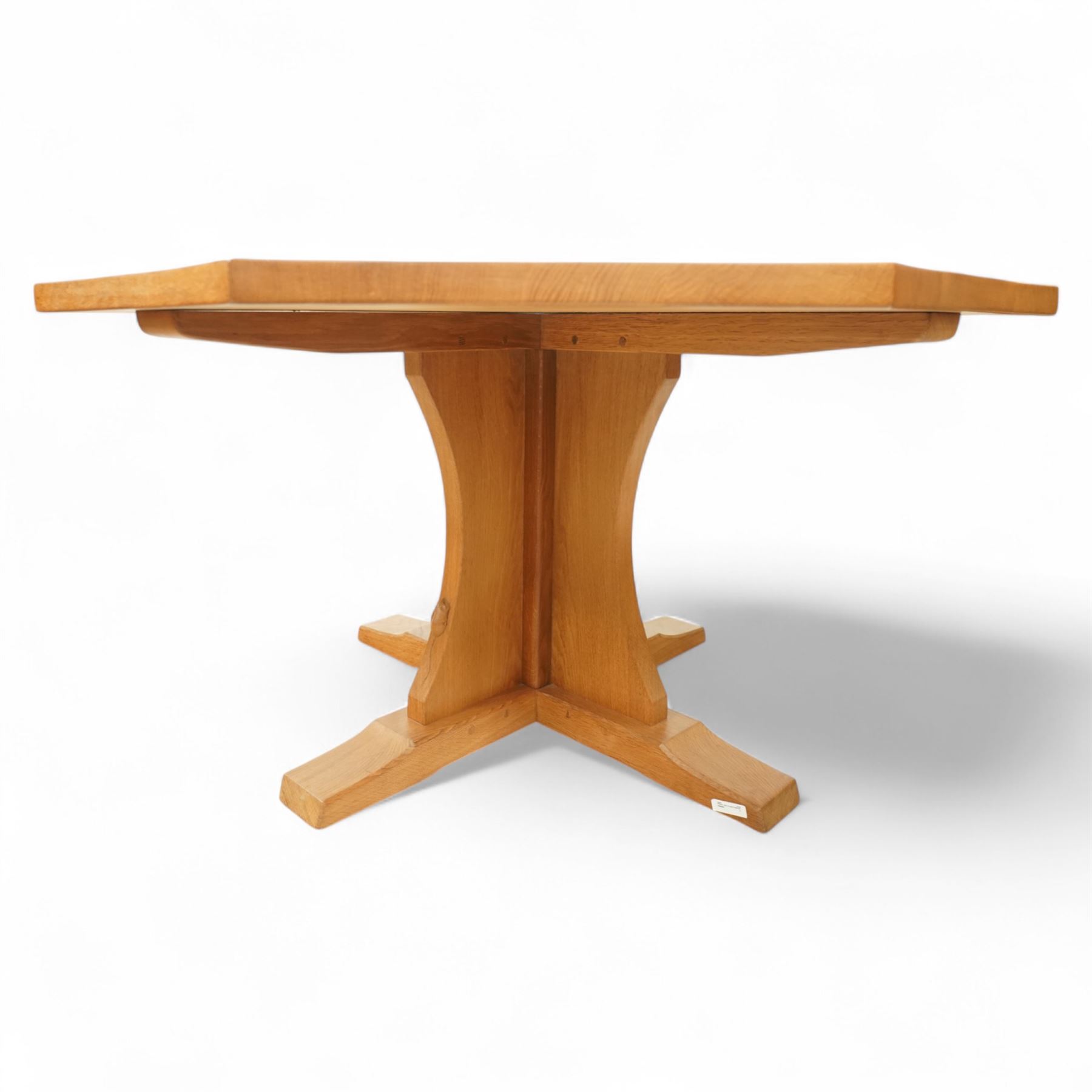 Mouseman - adzed oak octagonal concave dining table, raised on cruciform base, the supports and sledge feet also adzed, carved with fat mouse signature, by the workshop of Robert Thompson, Kilburn