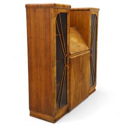 Art Deco walnut bureau bookcase, top with moulded and rounded edges and stepped front profile, central shelf, and fall-front bureau section with vertical and horizontal pigeon holes and a small drawer, above two cupboard doors and flanked by two tall glazed display cabinets with single doors and geometric sunburst design astragal glazing bars enclosing three shelves, raised on cavetto shaped plinth base 