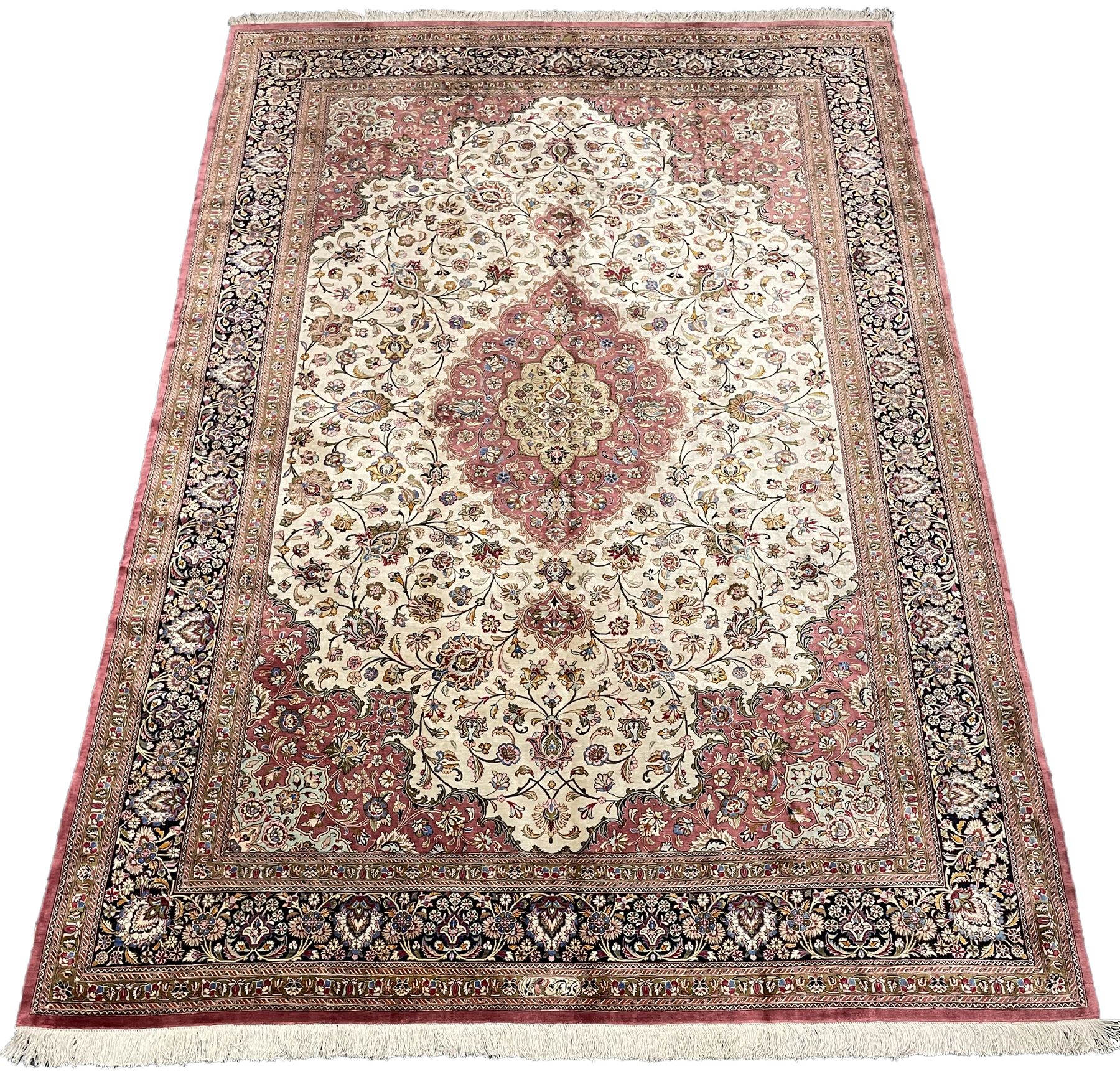 Finely knotted Persian Qom silk rug, overall pink ground with ivory field, the field with central cusped medallion profusely decorated with interlacing foliate and stylised flower heads, multiple band boarder, the main band decorated with a series of stylised motifs and trailing foliage, the outer guard with signature panel 