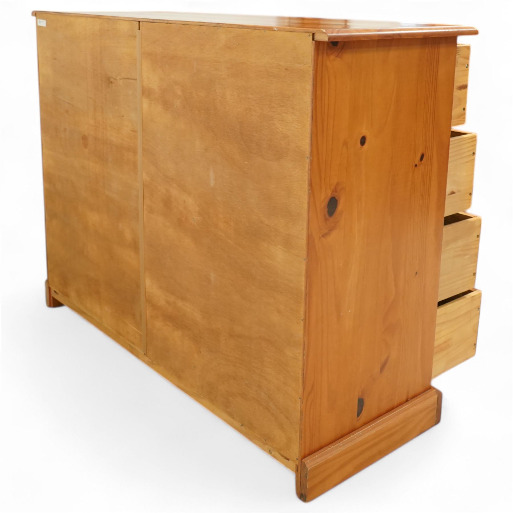 Late 20th century pine merchants chest, rectangular top over an arrangement of twelve small and four larger drawers, each with recessed panel facias and brass cup handles, plinth base