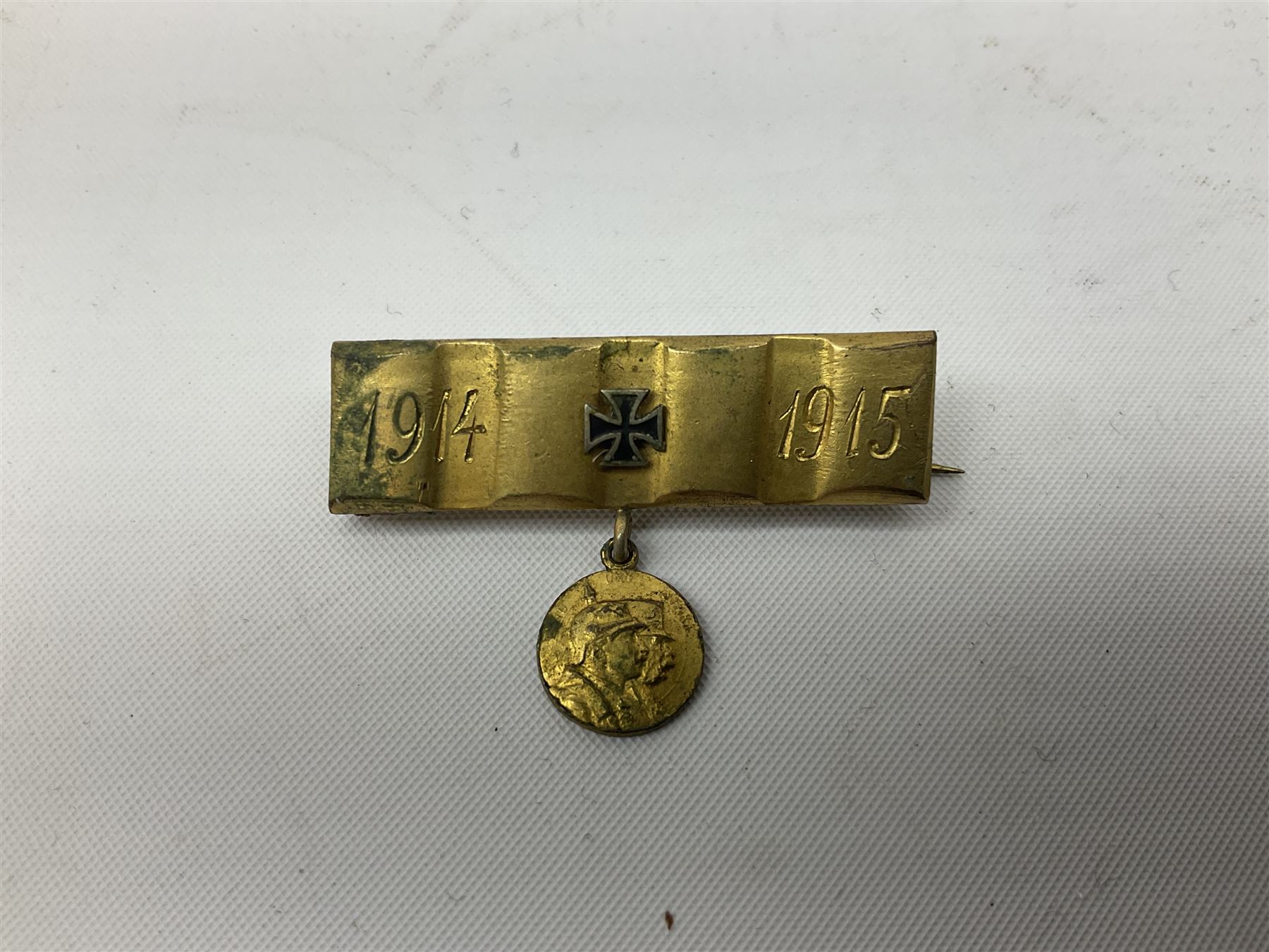 Two WW2 German Army Afrika Korps pith helmet metal side badges; RAD oval metal badge by J.B.u.Co.; WW1 German 1914-1915 bar brooch; and Nienburg War Veteren's Association badge (5)