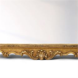 Georgian design giltwood overmantel mirror, arched rectangular plate within a moulded frame, the cresting carved with scrolling acanthus and shell motifs, trailing foliate decoration continuing to the shoulders and lower apron