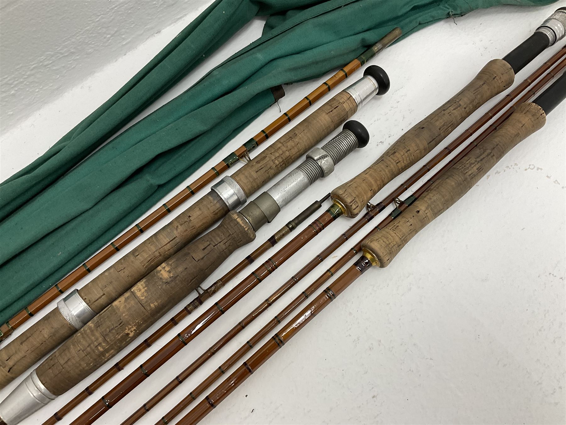 Four split cane fly fishing rods, three made by Burn of Selsdon, the four unmarked, housed in rod bags and a card tube