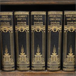Small Edwardian mahogany open bookcase with Charles Dickens books, oak bookcase with galleried top, containing fifteen hardback books  
