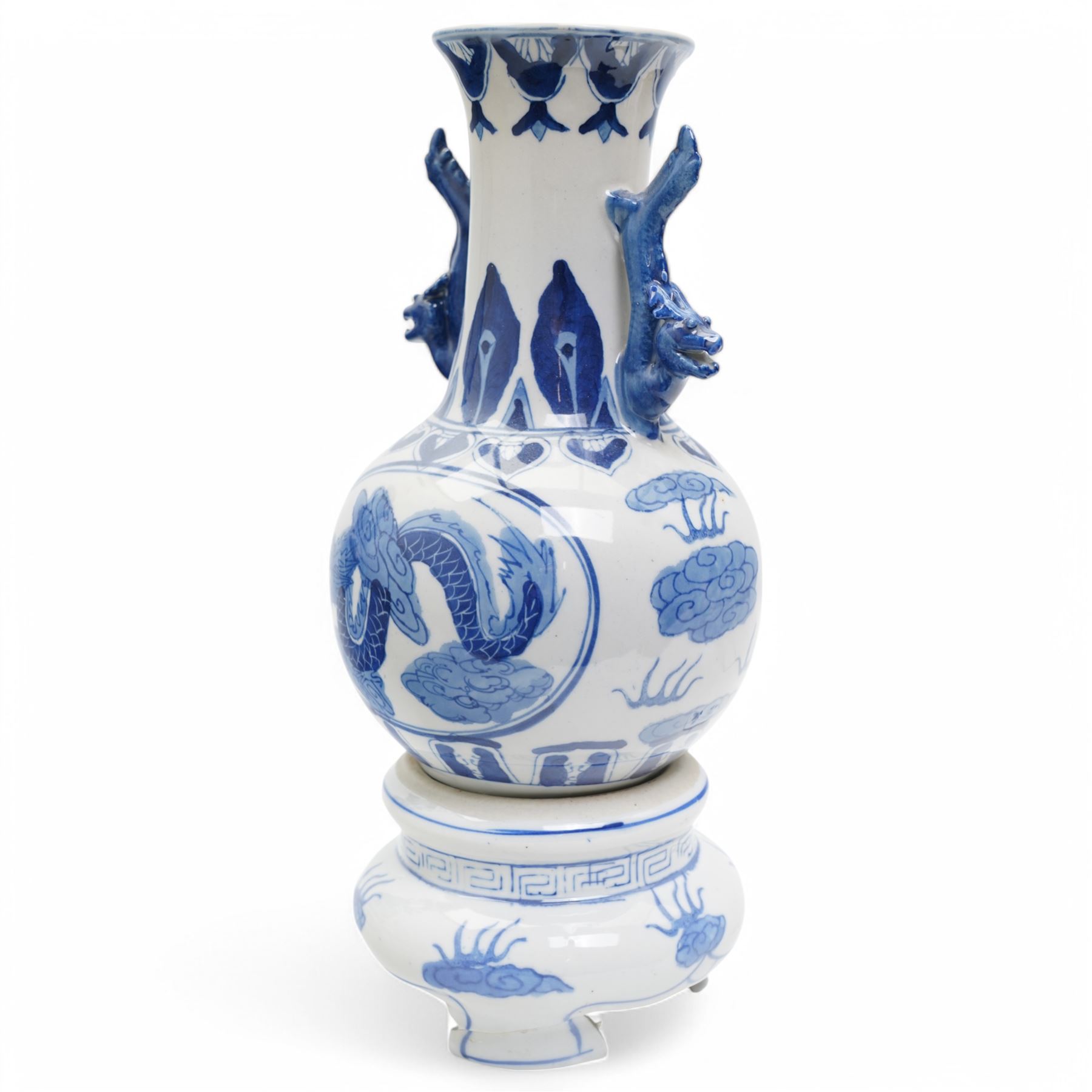 Pair of Chinese blue and white vases and stands, of baluster form with elongated neck, decorated with painted scenes of dragons amongst clouds, the twin handles formed as two crouching dragons, including stands H32cm