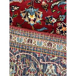 Persian Kashan rug, red ground and decorated with stylised flower heads, central blue ground medallion and matching spandrels, scrolling design guarded border
