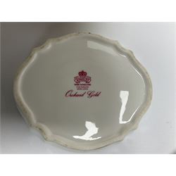 Collection of Aynsley Orchard Gold pattern wares, comprising lamp base, three jars and covers, six vases or various size and form, large jug, lidded dish, pair of cruets, pair of candlesticks, mug, two pin dishes, lobed dish, tea cup, saucer, size plate, and cake plate, and two further cups and saucers, each cup decorated with central Orchard Gold reserve to the interior against a mottled pink or green ground. 