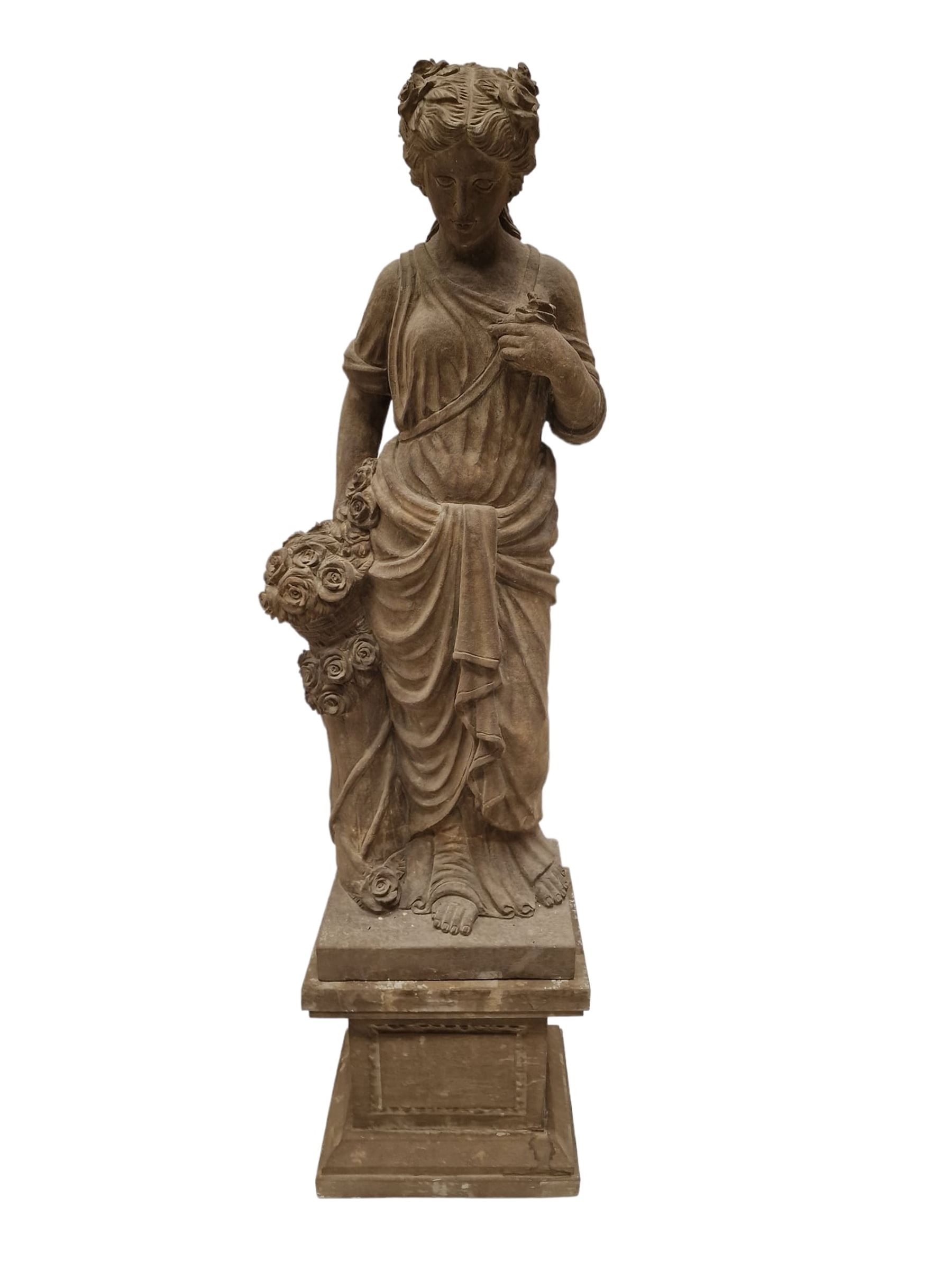 Hand carved stone Neoclassical figure of the Roman goddess Flora, her hair pinned with roses, draped in a toga, holding a basket of flowers in her right hand, raised on a stepped square plinth base 
