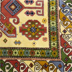 Caucasian Kazak design wool rug, cream field with three large geometric medallions and stylised hooked motifs, enclosed by polychrome reciprocal border and green floral guard stripes