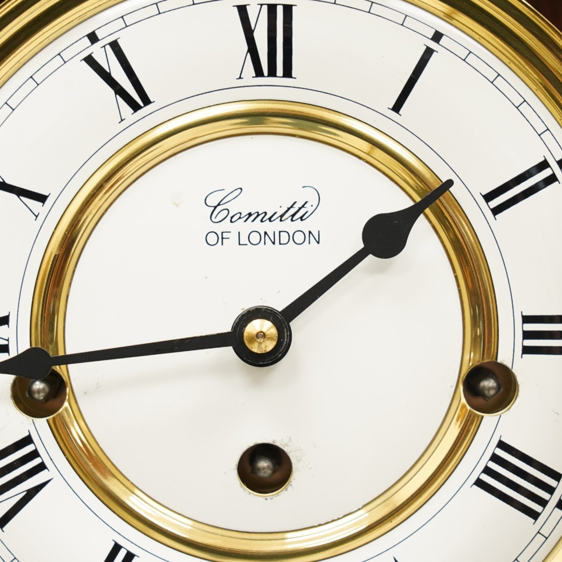 Comitti of London - burr walnut three-train wall clock, the circular dial with Roman numerals, glazed case revealing the movement and brass pendulum