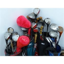  A quantity of golf woods, irons and putters, with six bags, three umbrellas, box of Dunlop 18 golf balls pack, box of Wilson ultra-distance 12 gold balls and other golf balls   