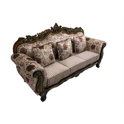 Italian Baroque design three seat sofa, hardwood framed, the cresting rail carved and pierced with c-scrolls and flower heads, scrolled arms, upholstered in floral patterned and striped fabric, with scatter cushions 