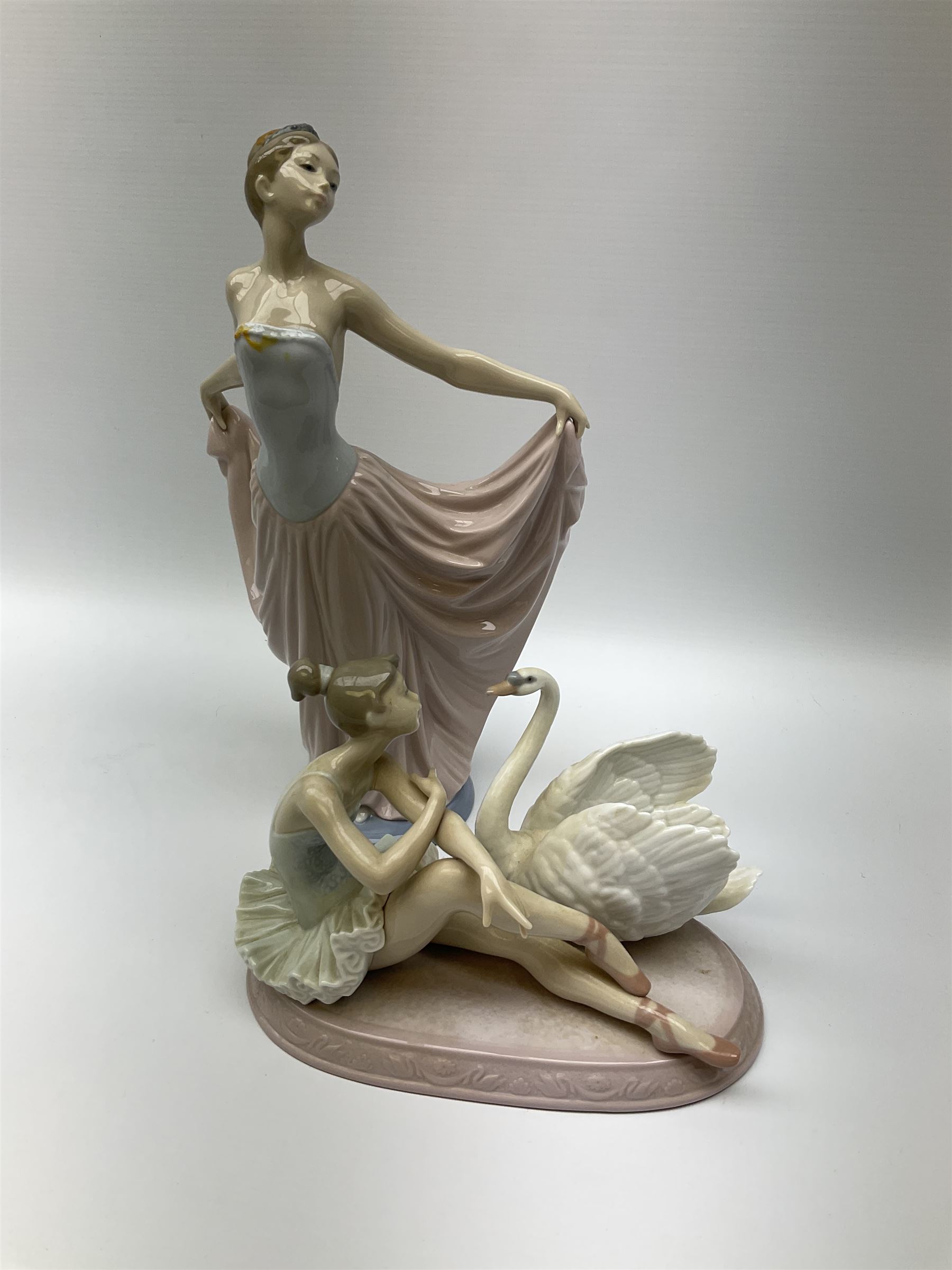 Collection of seven Lladro figures, including Seated ballerina with swan 6204, Childhood Dream 8129, Dancer 5050, reclining clown with ball alongside a selection of other figures. 
