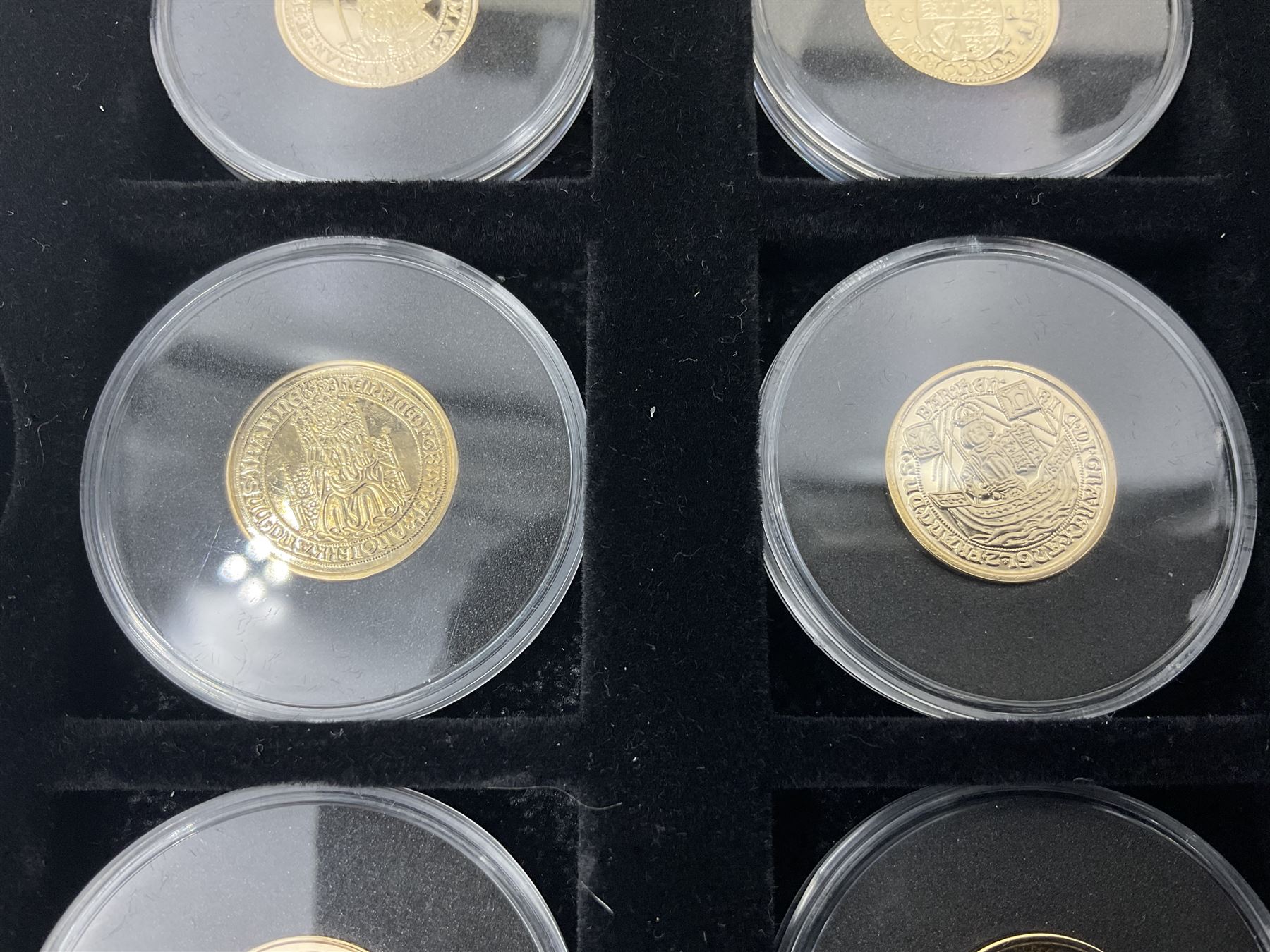 Sixteen hallmarked 9ct gold replica coins from 'The Historic Coins Of Great Britain Museum Gold Collection', housed in a Westminster display case, overall weight approximately 51.3 grams