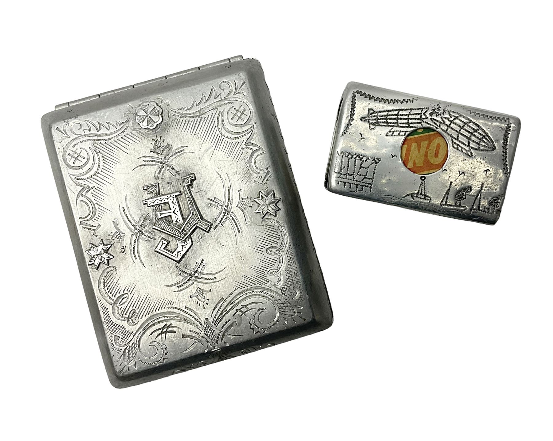 Aluminium cigarette case, by repute made from the R.38. Airship wrecked over Hull August 24th 1921, together with a aluminium matchbox cover, the front inscribed 'R38 WRECKED AT HULL 24 AUG 1921 44 LIVES LOST', the event illustrated verso, (2)