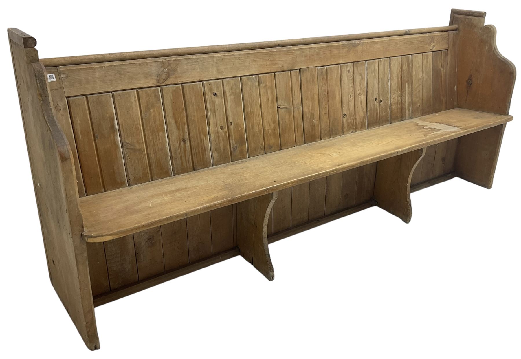 Early 20th century pine church pew, vertical plank back over rectangular seat, flanked by shaped end supports, with bible rest to back