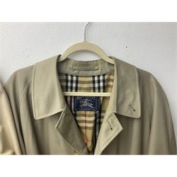 Ladies Burberry double breasted trench coat, with belt and detachable woollen gilet, in traditional cream colour with Burberry check lining, together with a gentlemans Burberry single breasted trench coat, both L112cm