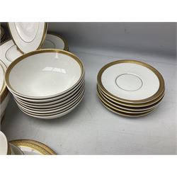 Royal Doulton Royal Gold pattern tea and dinner service for eight, comprising dinner plates, side plates, tea plates, soup bowls, sauce boat and saucer, dessert bowls, coffee cans and saucers, teacups and saucers and two lidded tureens