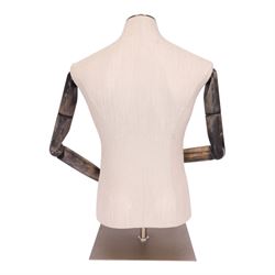 Male mannequin torso with fabric body and poseable wooden arms, on a square metal base