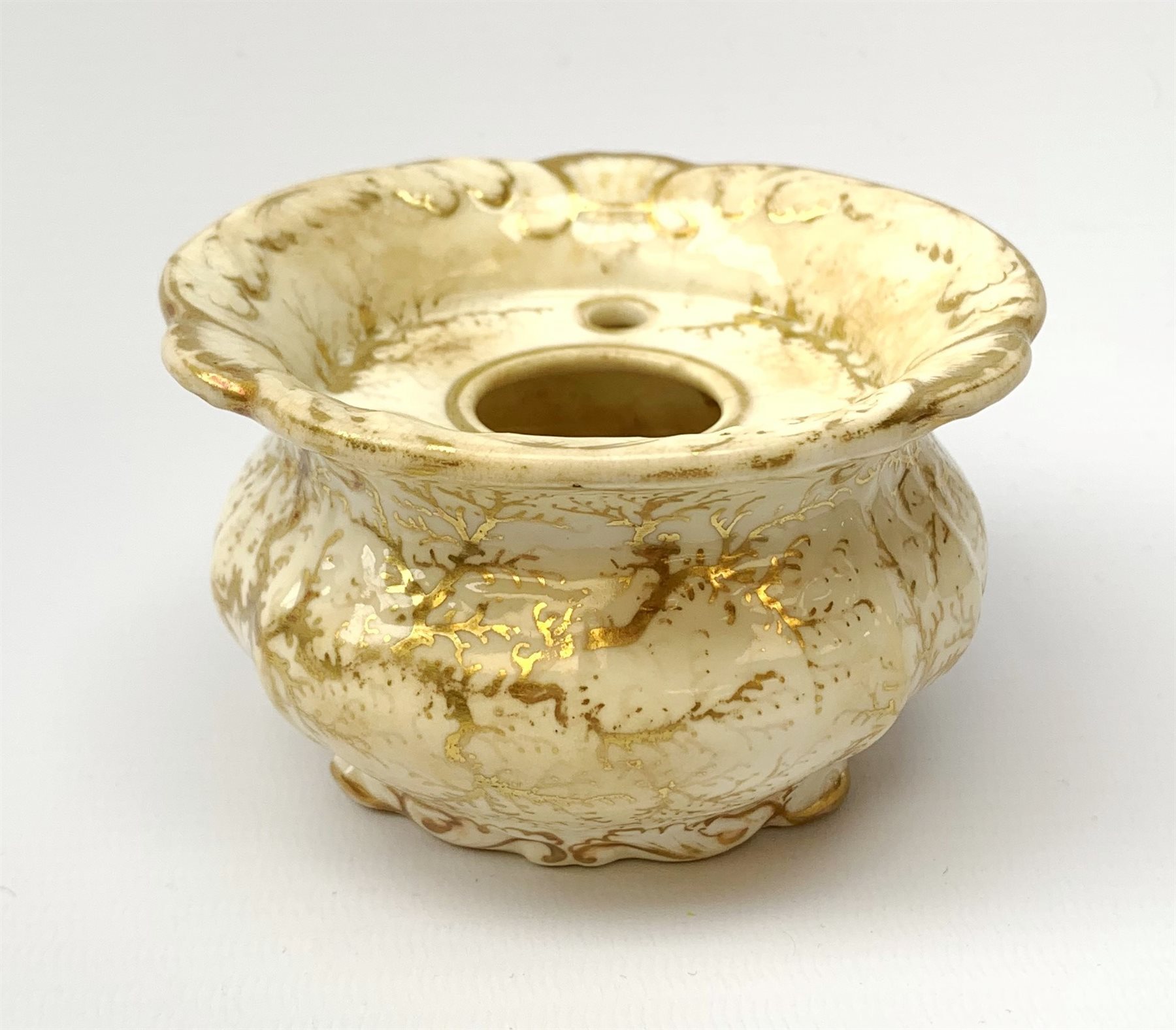 A Rockingham inkwell, with scroll rim, the whole decorated in gilt with a seaweed pattern, with a printed puce mark beneath, D9.5cm. 