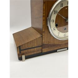 A 1930’s eight-day three train art deco Westminster chiming mantle clock with a Haller & Benzing (German) movement chiming the quarters on five underslung gong rods, silver effect chapter ring with upright Arabic numerals and minute track, strike/silent lever, chrome spun bezel with a convex glass, pierced chrome hands, walnut veneered case inlaid with cross banding and inlaid with amboyna and ebony.
With pendulum.
Haller & Benzing were a short-lived firm of German clockmakers with a factory in Villingen-Schwenningen from 1918 to 1929, mainly known for producing industrial clocks, their domestic clocks are not as well known. 

