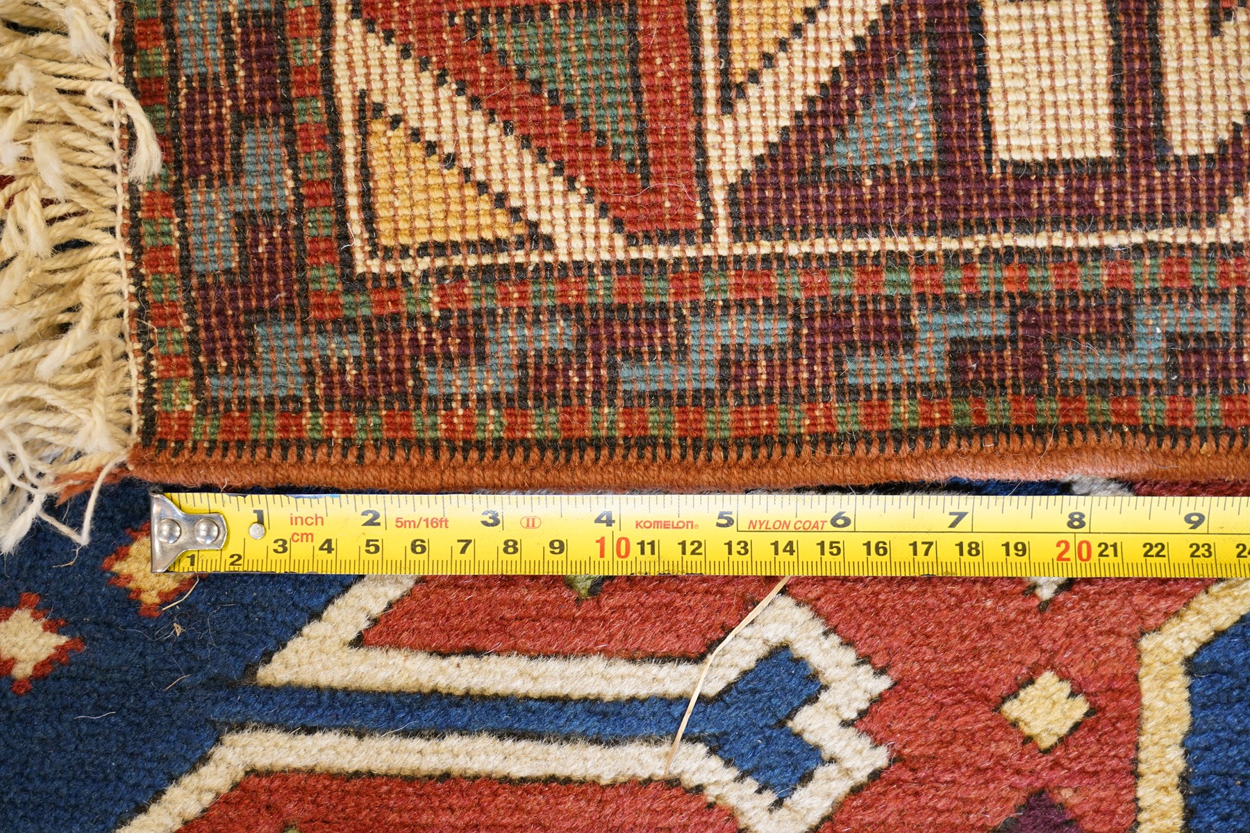Caucasian Kazak indigo and vermillion ground rug, the geometric field boldly woven with two medallions interspersed with symbolic tribal motifs and shapes, with contrasting ivory guard band
