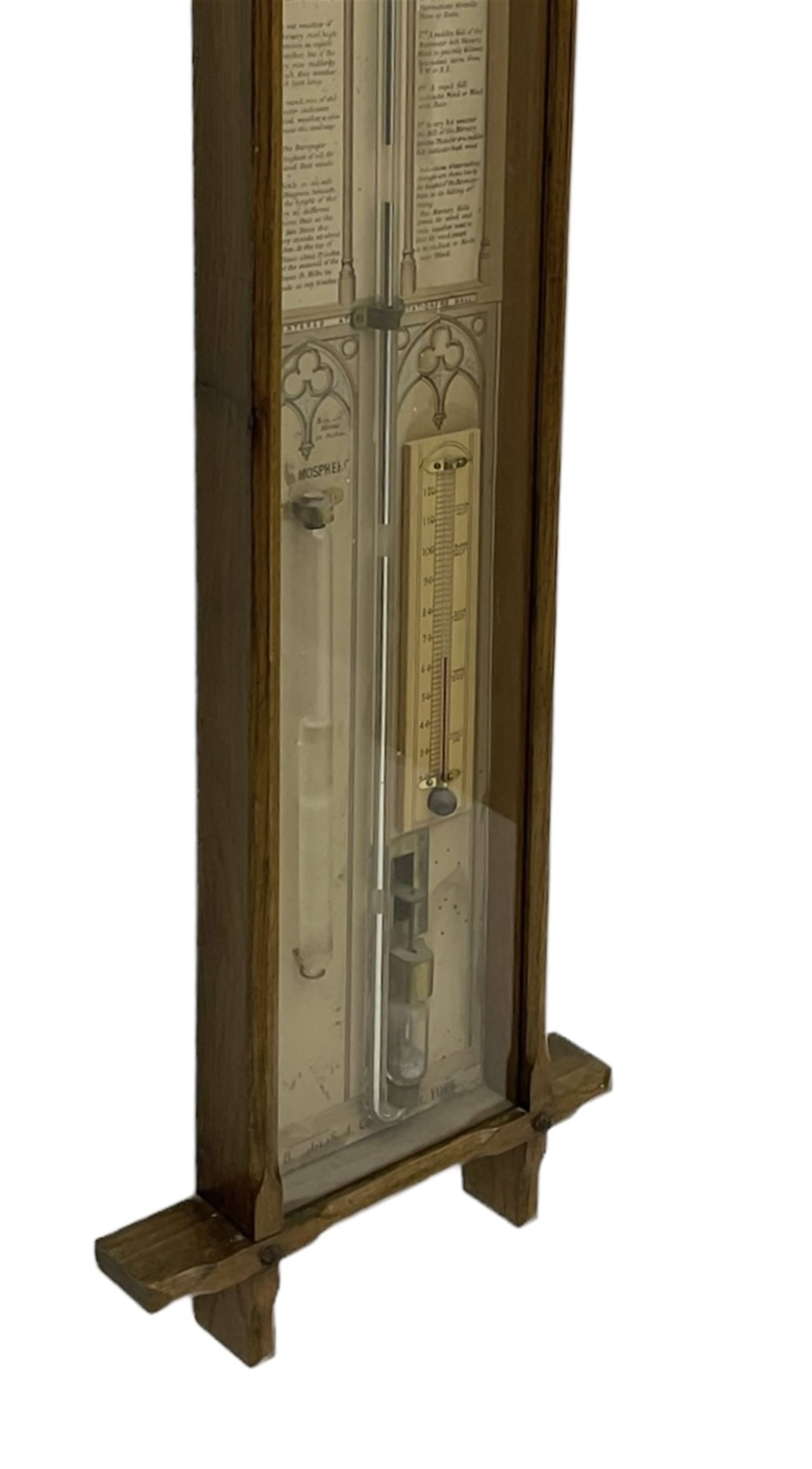Admiral Fitzroy - Early 20th century Fitzroy barometer in a glazed gothic influenced oak case with chamfered uprights and top and base panels, full length paper scales with Fitzroy's observations and predictions, mercury bulb cistern, storm glass, spirit thermometer and brass sliding vernier pointers. Retailed by Inglis & Son, Coney Street, York.