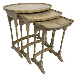 Mid 20th century bleached walnut nest of three tables, oval piecrust tops on turned supports