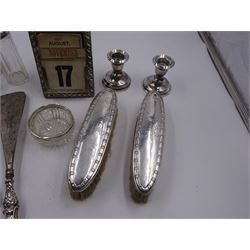 Group of silver, comprising Victorian silver mounted perpetual calendar with various date cards, hallmarked Henry Matthews, Birmingham 1900, silver mounted dressing table items, to include hair brush, with embossed decoration, pair of clothes brushes, and a shoe horn, together with a pair of silver mounted dwarf candlesticks, four cut glass jars/scent bottles with silver covers and a cut glass open salt with silver collar, all hallmarked 