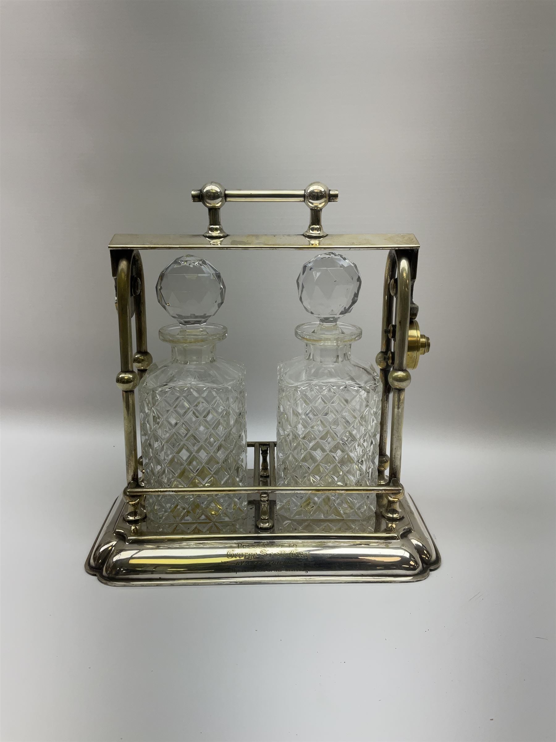 Early 20th century silver plated tantalus by John Grinsell & Sons of Birmingham, containing two crystal glass decanters, with key, H31cm