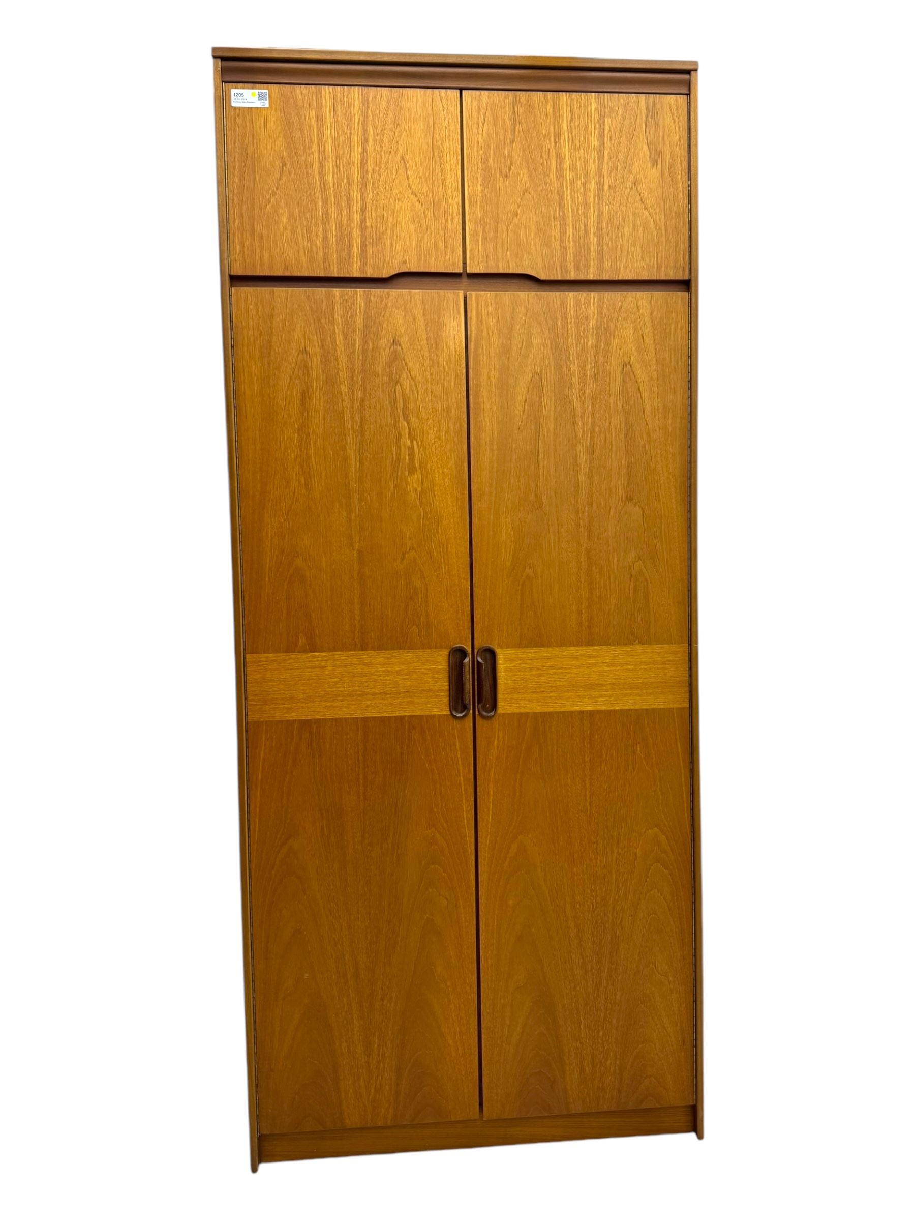 William Lawrence - mid-20th century teak double wardrobe, upper storage section over twin doors featuring recessed handles and contrasting horizontal panel, enclosing hanging rail compartment, towel rail, mirror, shelves and drawer, on plinth base with concealed castors