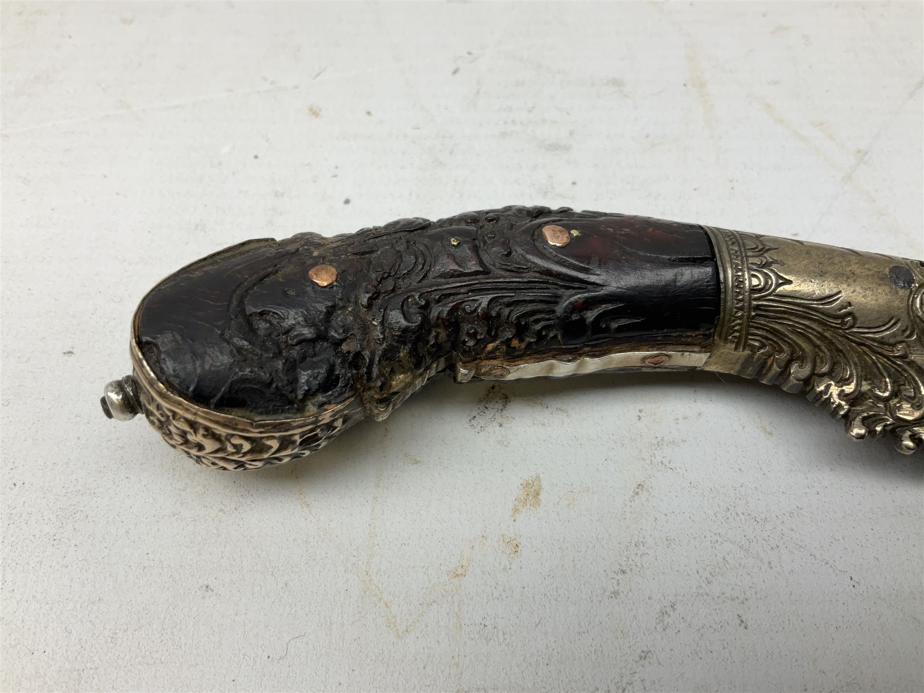 19th century Singhalese knife pia kaetta, the 20cm steel blade inset with yellow and white metal, with metal mounted carved pistol grip, in plain wooden scabbard L33cm overall