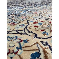 Central Persian Nain carpet, the deep blue field with finely drawn scrolling palmettes and flowering vines around a central ivory and sky blue rosette medallion, enclosed by an ivory border of interlaced floral arabesques and lotus forms between multiple guard stripes, from the region of Nain