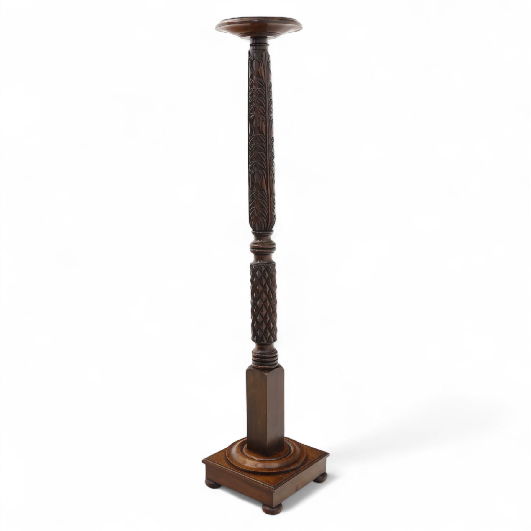 Late 20th century carved mahogany torchère stand, dished top above heavily carved column, with turned elements on moulded square base upon bun feet
