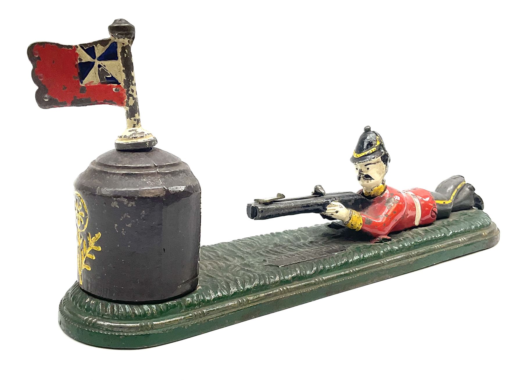 Very rare 19th century John Harper & Co. mechanical cast-iron money box, registered number 33821 patented 1885, inscribed on metal plaque 'Wimbledon Bank', based on the Queen's Trophy for shooting at Wimbledon, depicting a British Infantry man in red tunic and blue trousers lying on the ground using a gun to fire a brass coin launcher into a pill box with removable moving flag above L30cm