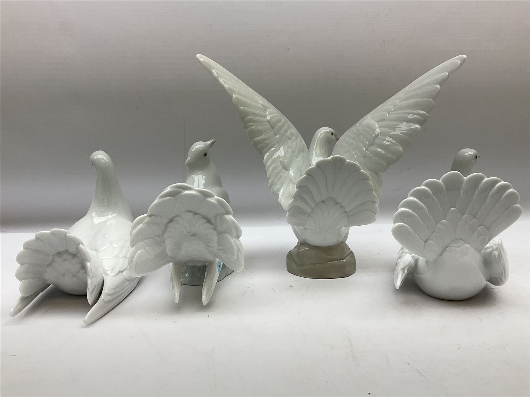 Four Lladro dove figures, comprising Taking Flight no 6288, Dove no 1015, Proud Dove no 6290 and Peaceful Dove no 6289, all with original boxes, largest example H20.5cm 