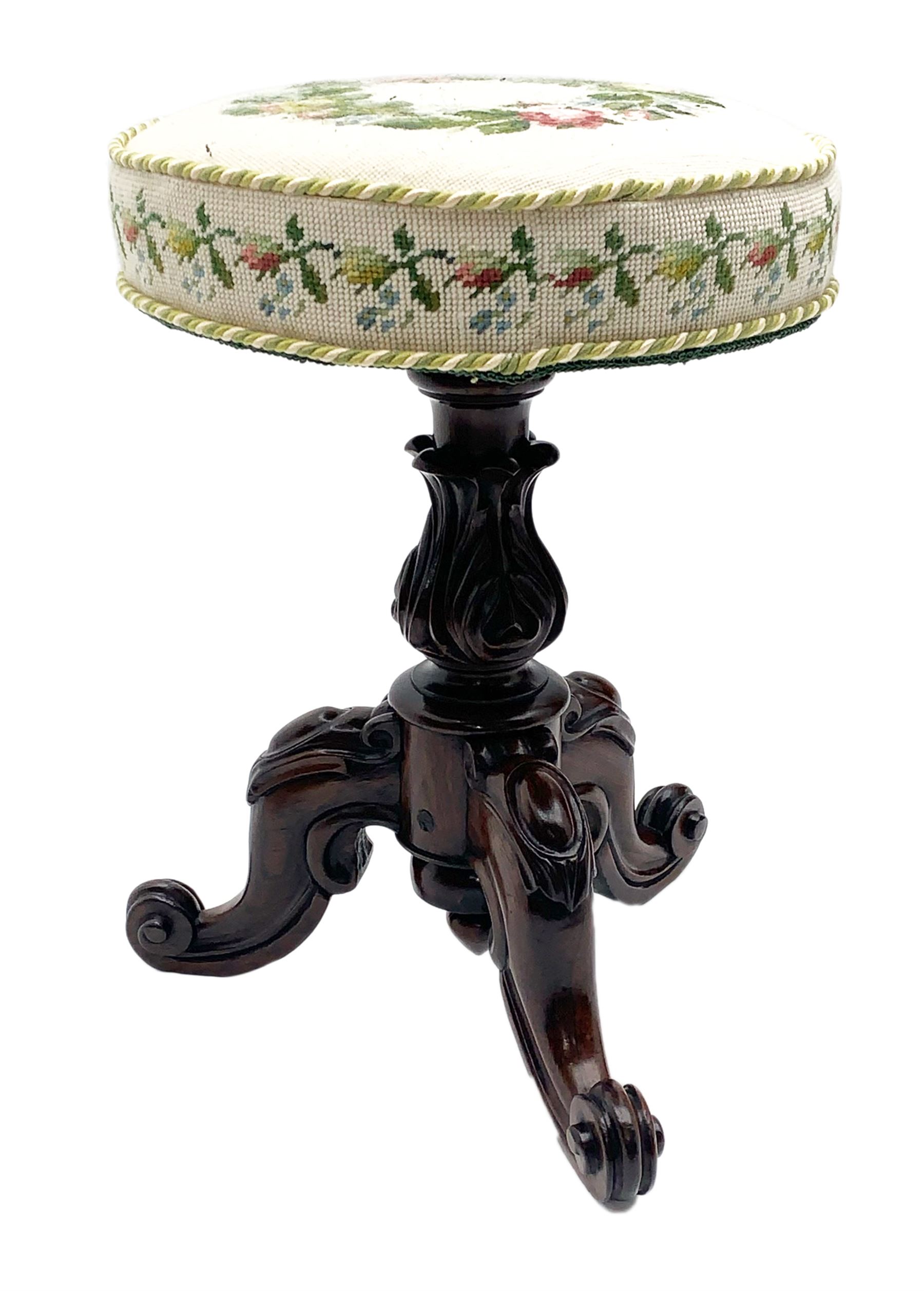 Victorian rosewood rise and fall piano stool, the floral needlework upholstered seat raised on floral and scroll carved tripod base