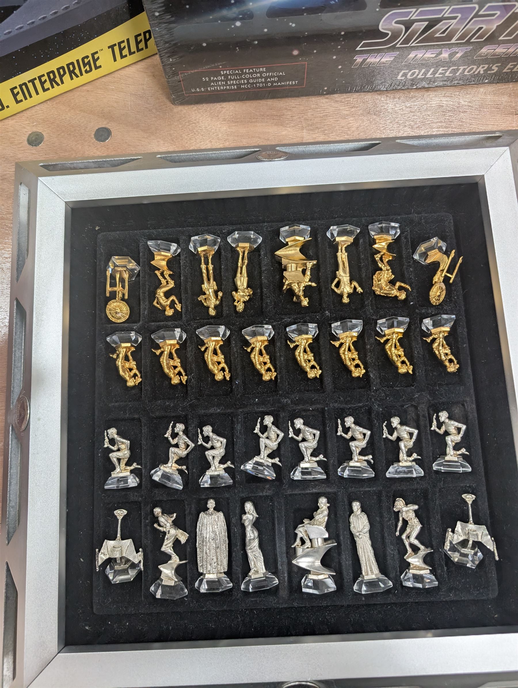 Star Trek Paramount Pictures Official Chess Set, incluidng glass board with removable lid, opening to reveal full set of gold and silver plated pewter figural chess pieces, with certificates, together with a Star Trek USS Enterprise Telephone, Star Trek Monopoly, 30th Anniversary DVD box set, Star Trek novels, DVDs, CDs, etc