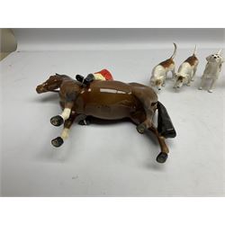 Beswick hunting group, comprising huntswoman on grey horse no 1730, huntsman on brown horse no 1501, two seated fox figures no 1748 and seven fox hounds, all with printed marks beneath (11)