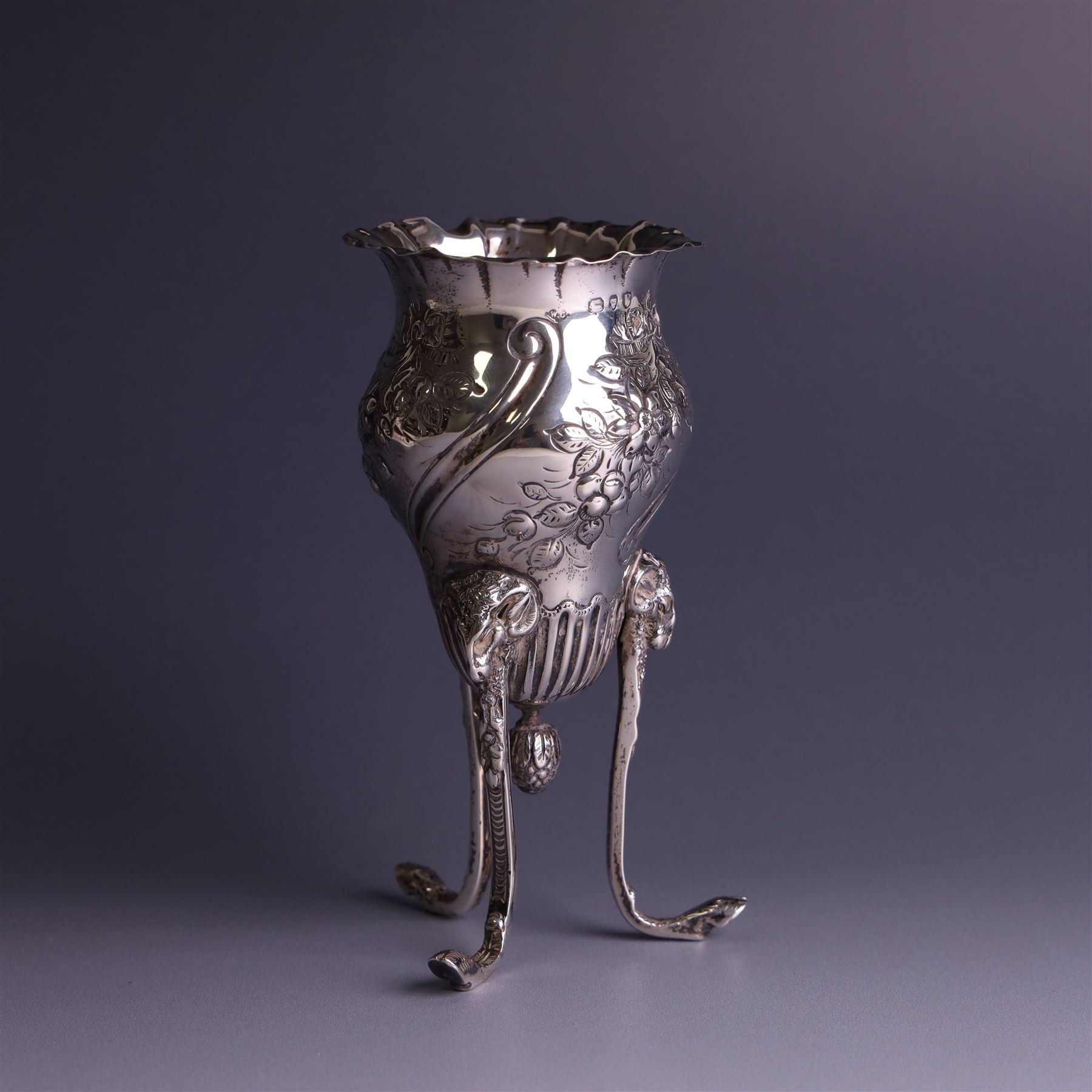 Late Victorian silver vase, of baluster form with fluted rim, the body with embossed floral decoration, upon three tall legs with ramshead mounts, hallmarked William Comyns & Sons, London 1890, H13.5cm