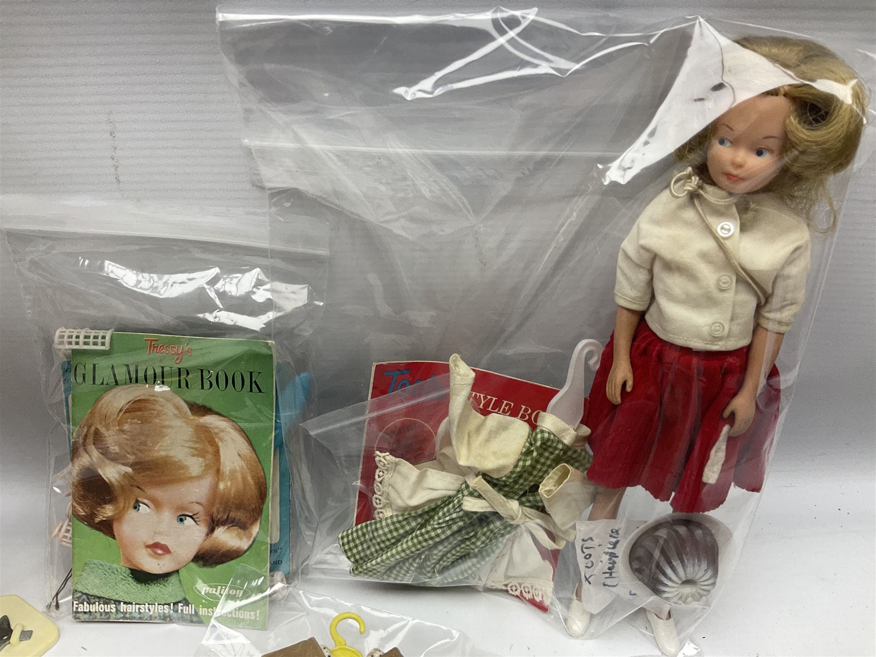 1960s Palitoy Tressy fashion doll, boxed with stand and booklets; four additional Tressy outfits (In The Office, Winter Journey, Winter Sports and Evening Date); two other outfits; and Tressy's Little Sister Toots doll with Style Book and additional outfit